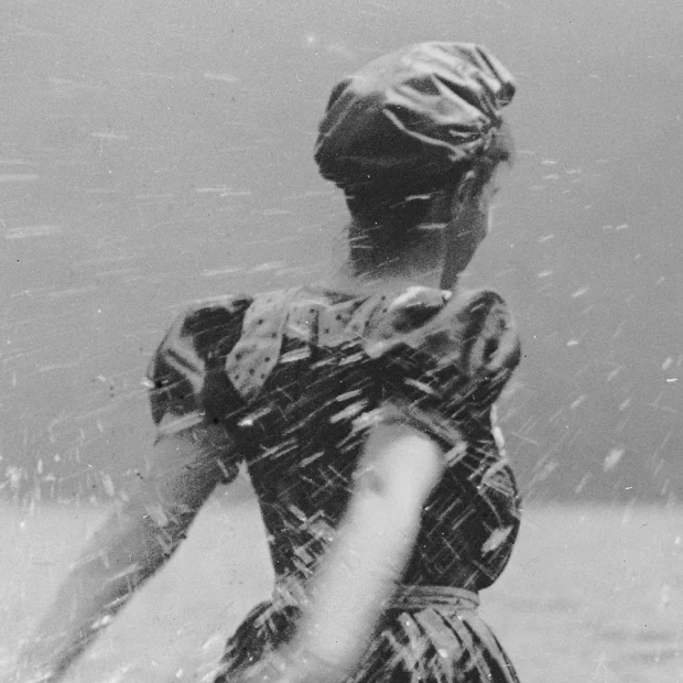 Femme sur la plage, éclaboussant l’eau.